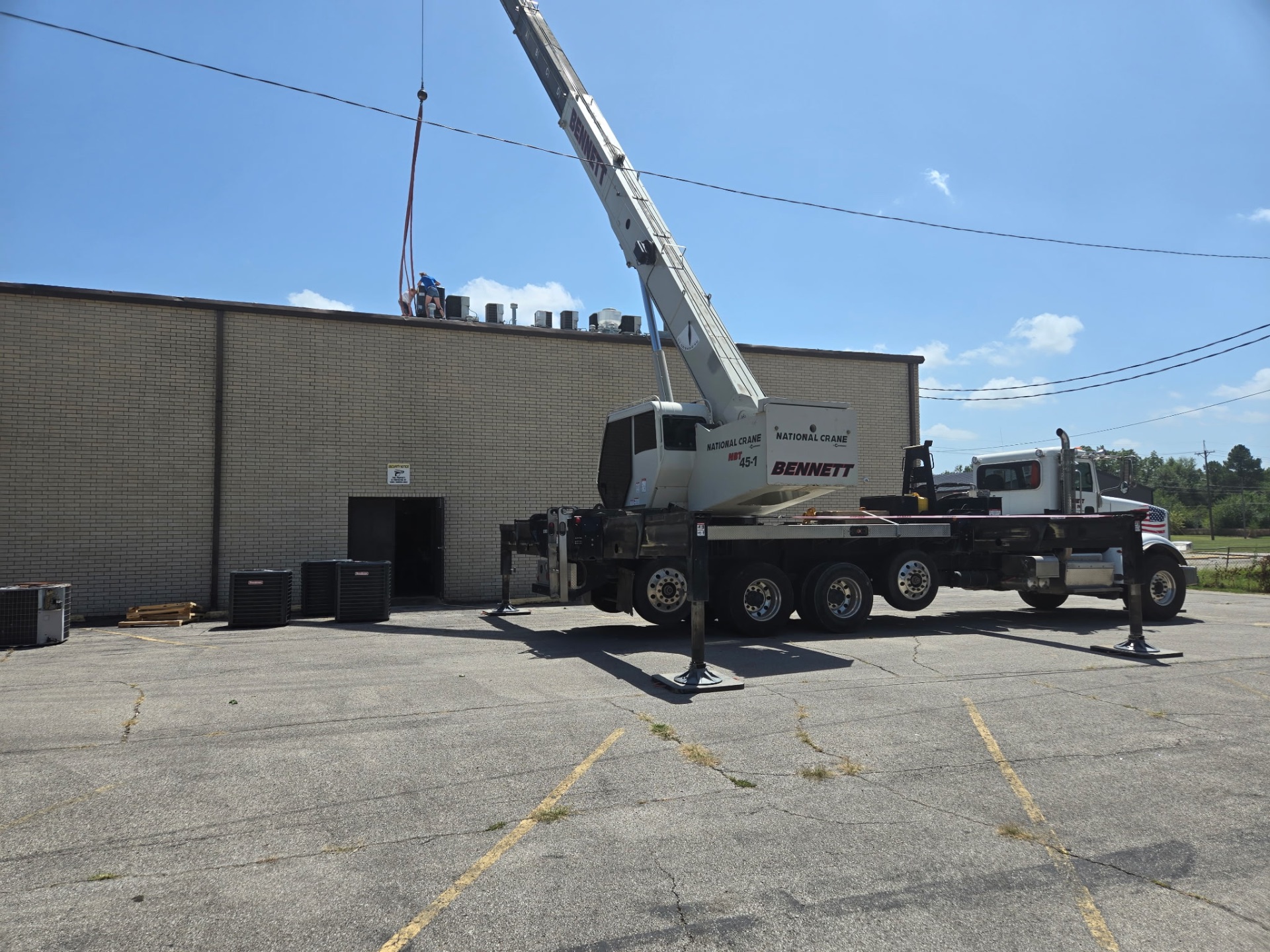 Commercial HVAC replacement jobsite with crane staged in parking lot